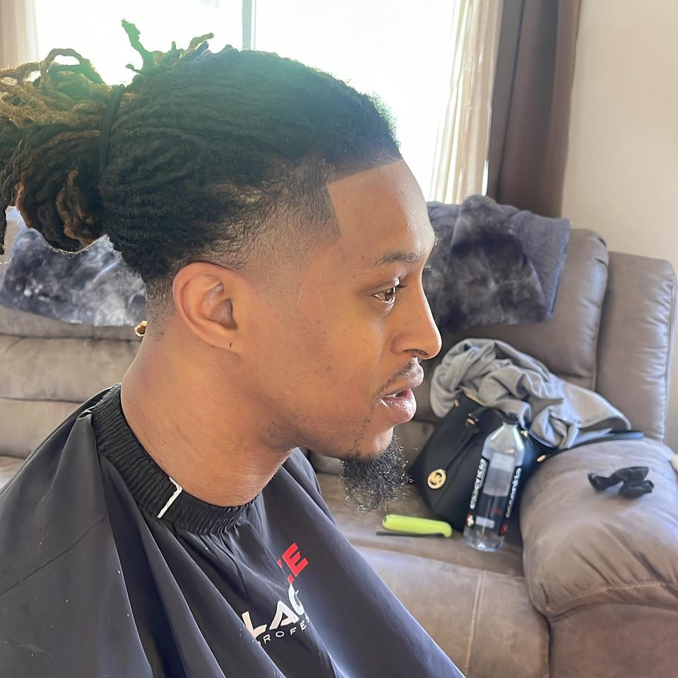 Right-side view of a clean temple taper and line-up with locs pulled back